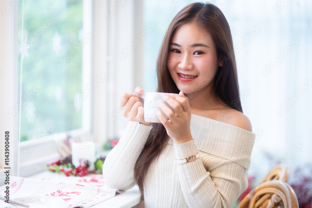 Portrait beautiful asian woman holding of positive the having cup of coffee,milk or chocolate at home in the living room indoors Decoration During Christmas x-mas and New Year holidays.