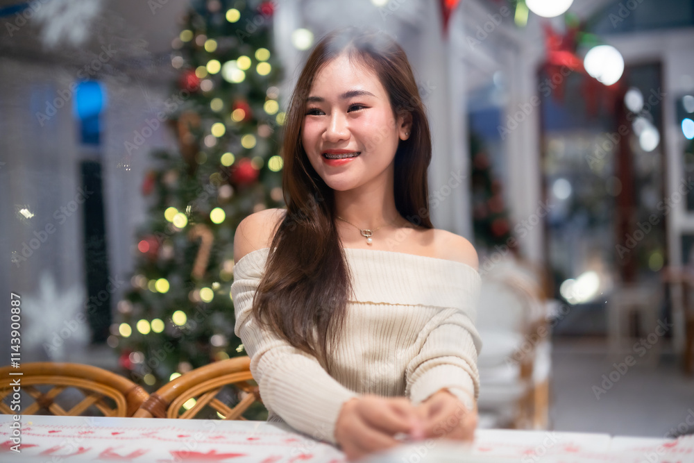 Portrait of beautiful happy Smiling asian woman relaxing sitting decorating to a Christmas tree at home in the living room indoors Decoration During Christmas x-mas and New Year holidays.