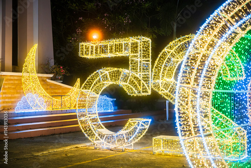 Obraz na płótnie PHITSANULOK, THAILAND - December 15,2024:Decoration lights Christmas tree for celebrate Christmas and New Year Festival 2025 illumination at Saint Nicholas School in Phitsanulok City at night w salonie