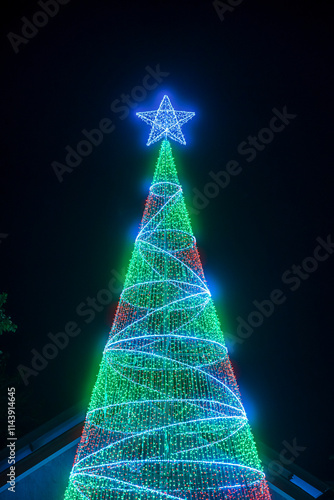 Obraz na płótnie PHITSANULOK, THAILAND - December 15,2024:Decoration lights Christmas tree for celebrate Christmas and New Year Festival 2025 illumination at Saint Nicholas School in Phitsanulok City at night w salonie