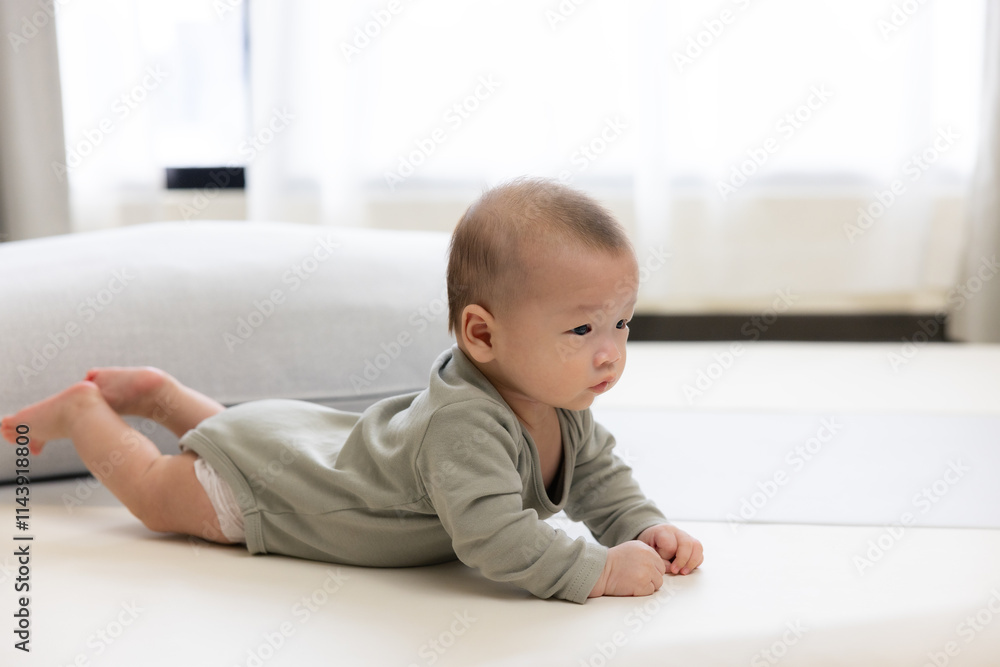 Baby lying on bed during tummy time exercise Baby lying on bed during tummy time exercise