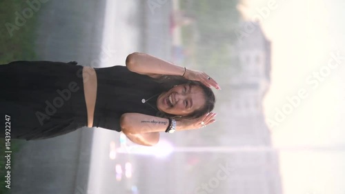 Asian girl falls under a fountain. Emotions of delight, joy, happiness.