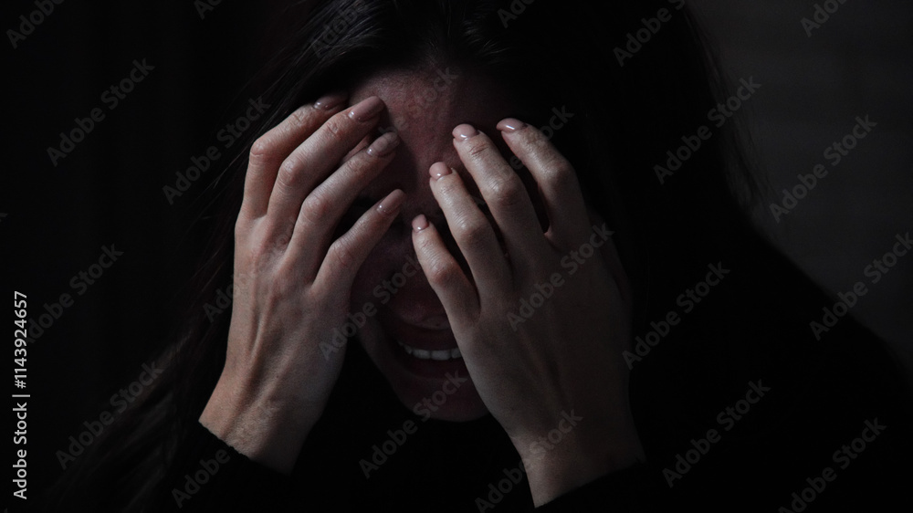 Silhouette of woman with mental health issues, sitting on the sofa, depressed expression, crying heart out, closing covering face with hands, close shot. Silhouette of woman with mental health issues, sitting on the sofa, depressed expression, crying heart out, closing covering face with hands, close shot.