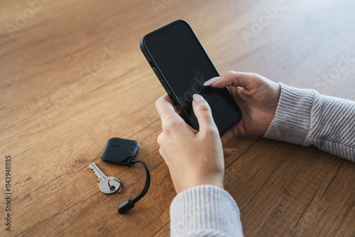 unknown woman hold wireless location accessory token to locate keys