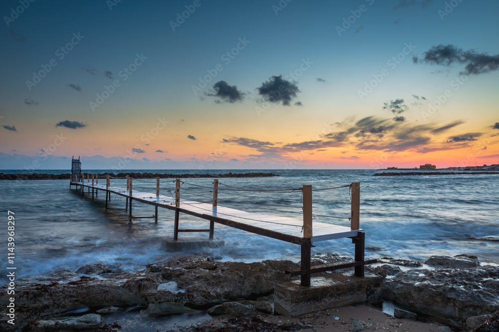 Obraz premium Sunset view along the coastline at Alykes Beach, Paphos, Cyprus