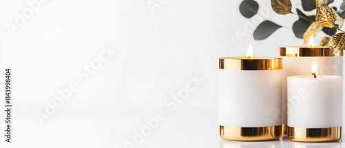 Elegant gold trimmed candle holders with white candles and greenery photo