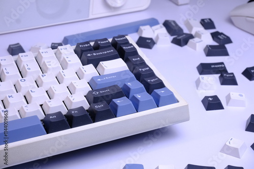 Modern 75% Layout White Mechanical Keyboard With Minimalist Theme of White, Blue, and Black Keycaps on a White Desk, with Scattered Keycaps