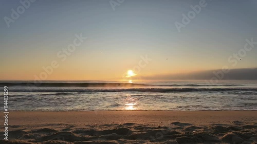 Sunrise from the seashore of the Balck Sea with fog over the water recorded at the blue minute. Varna beach, Bulgaria. 4K photo