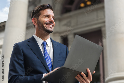 Happy investor use laptop conputer in front of the bank, get big good news when his loan amount credit approve, business of finance and founder or banker photo