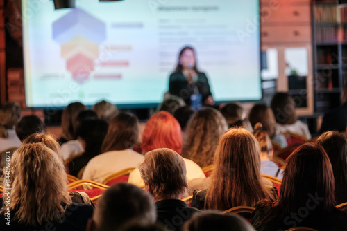 Wallpaper Mural Blurred audience listening to speaker presenting in modern conference room with projector screen. Torontodigital.ca