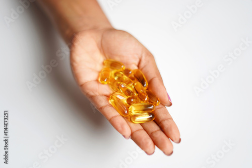 omega 3 capsules on hand image. closeup