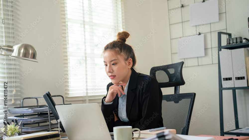 Businesswoman sitting at desk on couch in workplace or at home working on laptop and analyzing data on charts and graphs and writing on papers to make business plan and strategies for company, Businesswoman sitting at desk on couch in workplace or at home working on laptop and analyzing data on charts and graphs and writing on papers to make business plan and strategies for company,
