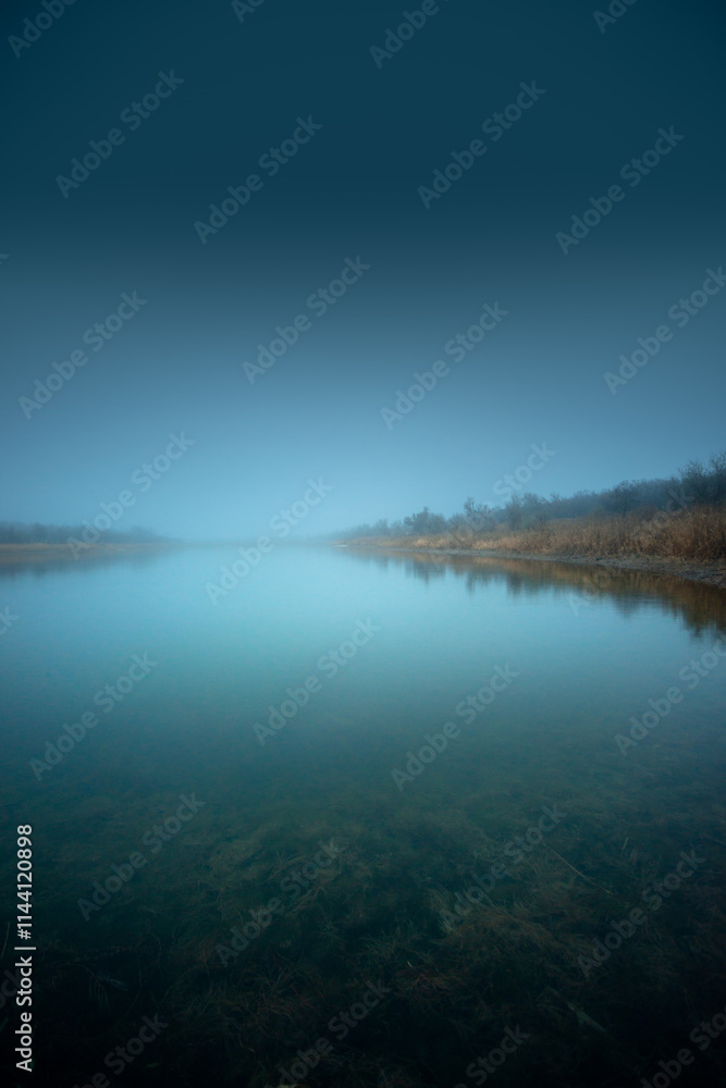 Autumn morning on the blu lake with fog , reflections on water ,landscape photography .Blue colors ,blue water ,mystery weather on the ponf.Forest near the pond , morning landscape at autumn season Autumn morning on the blu lake with fog , reflections on water ,landscape photography .Blue colors ,blue water ,mystery weather on the ponf.Forest near the pond , morning landscape at autumn season