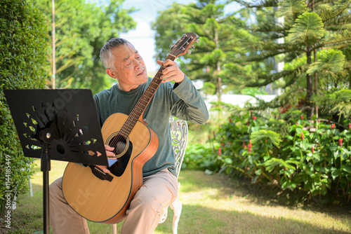 Wallpaper Mural Senior man a veteran guitarist plays music in the garden at home Torontodigital.ca