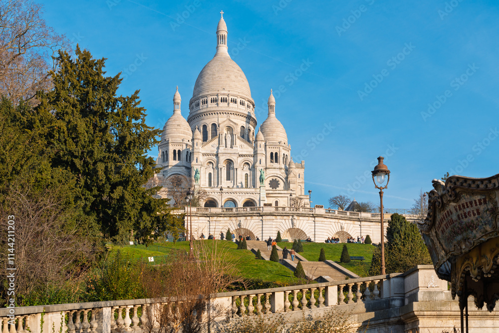 Obraz premium Sacré-Cœur Basilica in Montmartre, Paris, with blue skies and lush surroundings
