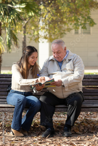 woman and grandfather filling out pastimes on a park bench