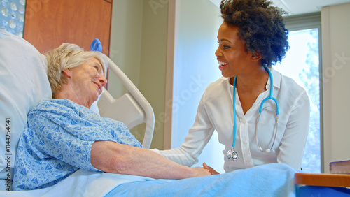 Female Doctor With Stethoscope Visiting Senior Female Patient In Hospital Bed Giving Her Good News