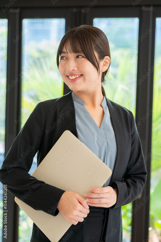 パソコンを持った笑顔の女性