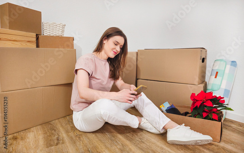 Student Sitting Among Moving Boxes with Phone on Moving Day