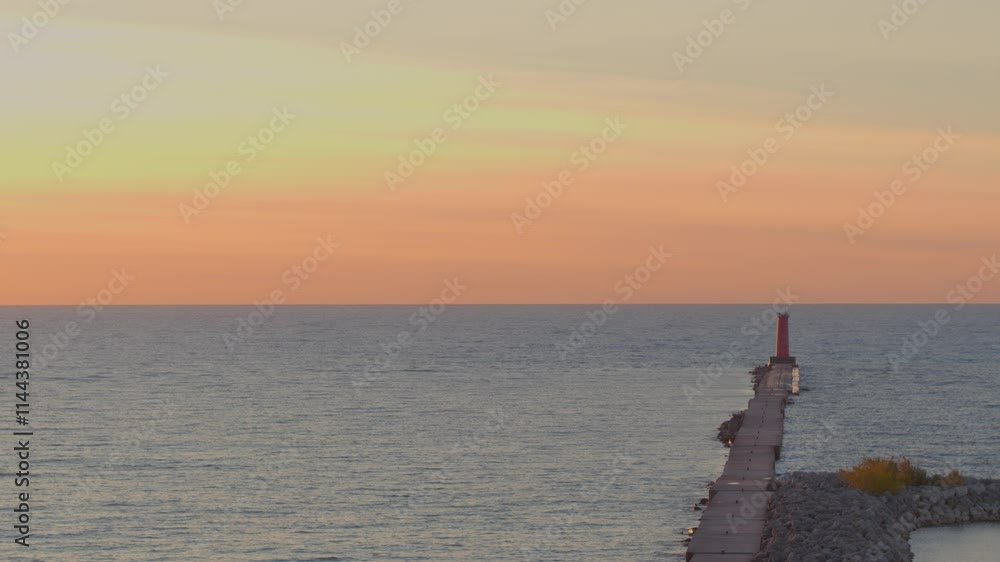 Aerial over Lake Michigan with push towards Sheboygan Lighthouse in Wisconsin at sunrise with a beautiful hombre sky and gentle relaxing waves Aerial over Lake Michigan with push towards Sheboygan Lighthouse in Wisconsin at sunrise with a beautiful hombre sky and gentle relaxing waves