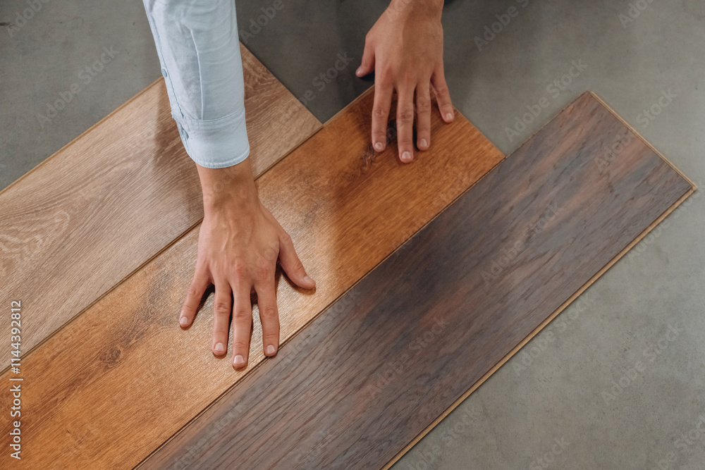 Surface of the parquet. Detailed close up view of man's hand in the hardware store Surface of the parquet. Detailed close up view of man's hand in the hardware store