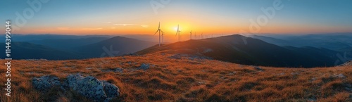 Spectacular sunset over rolling hills with wind turbines in the distance crea...