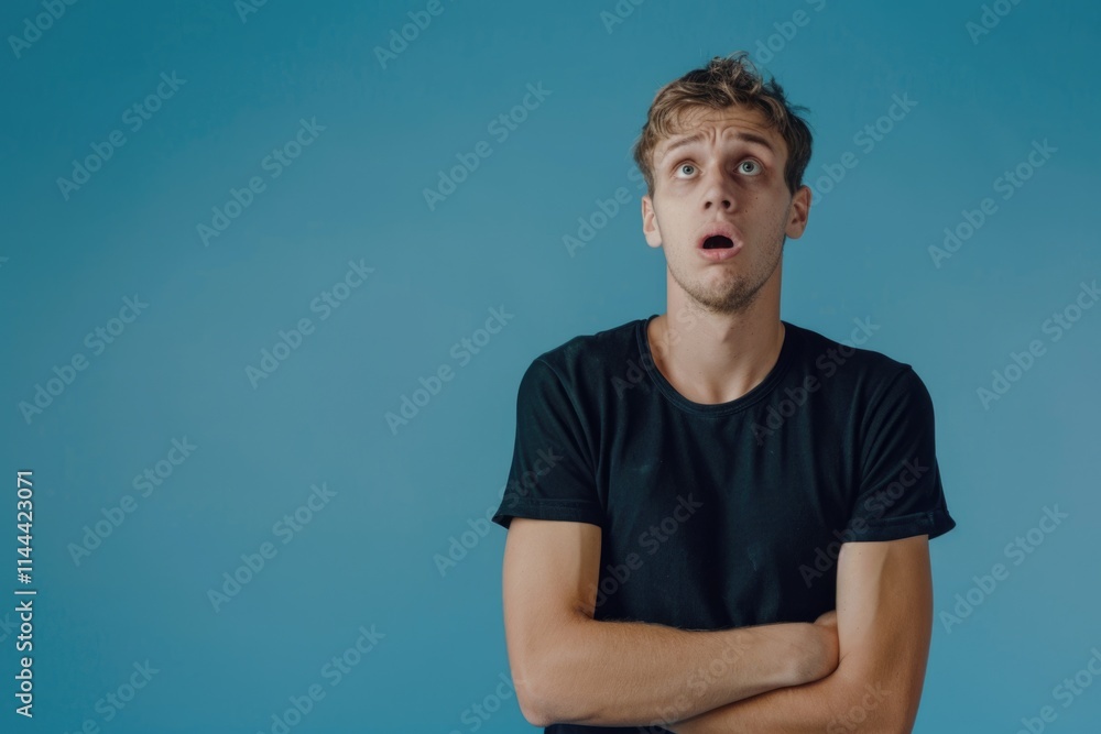 Young man shivering in fear or cold over blue background. Young man shivering in fear or cold over blue background.