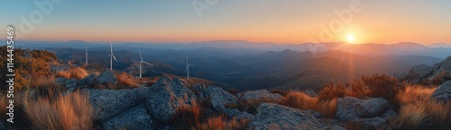 Spectacular sunset over rolling hills with wind turbines in the distance crea...