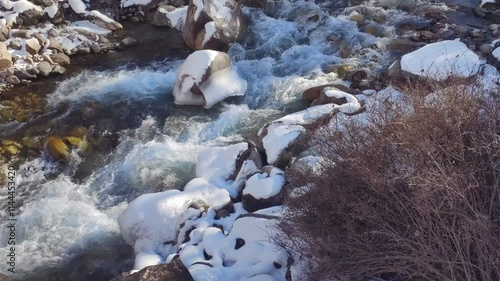  cold mountain river with ice and snoe in Kyrgyzstan