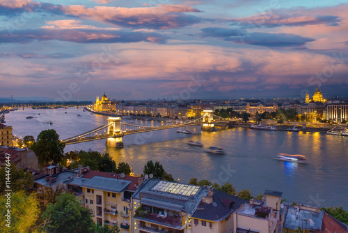 Obraz na płótnie View of Budapest at dusk, residential buildings in the foreground, the Szechenyi Bridge over the Danube River, and the Pest side of the city with the Hungarian Parliament Building in the background w salonie