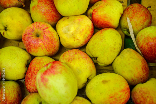Green red fruits in a fruit shop basket. Focus on fruit, noisy, exposure, similar others