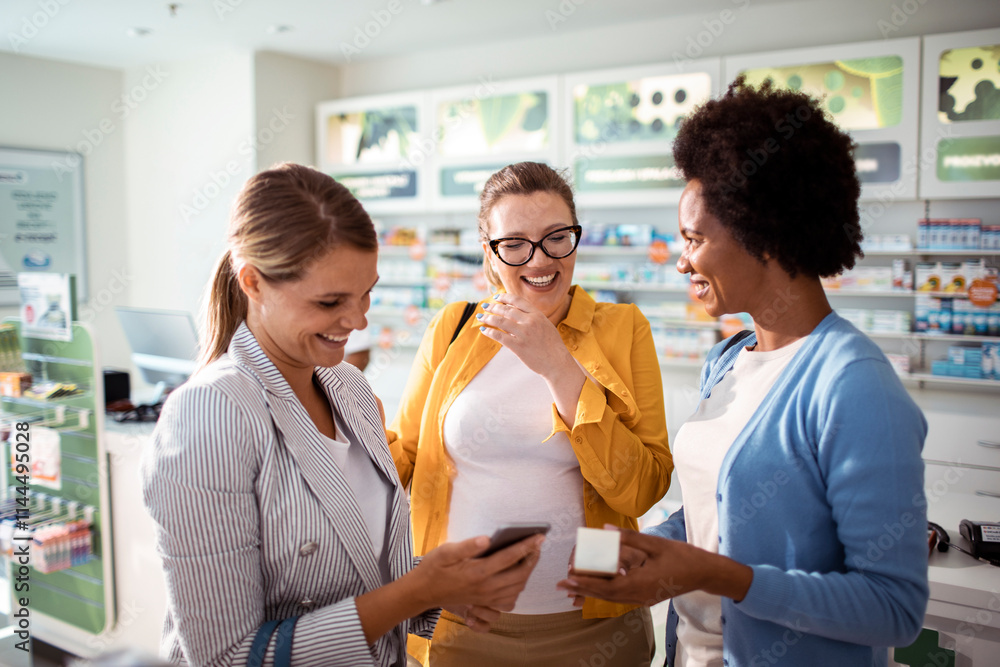 Happy pregnant woman shopping in drug store with friends Happy pregnant woman shopping in drug store with friends