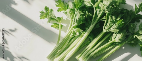 fresh celery stalks on a white surface