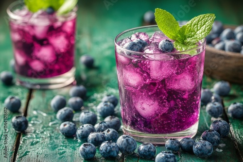 Refreshing blueberry mint drink served in glasses with ice and fresh mint lea...