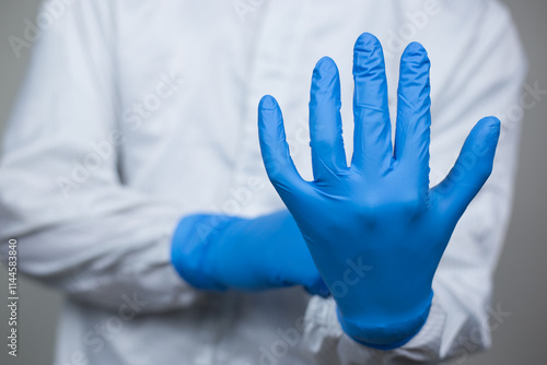 Doctor wearing nitrile gloves, isolated on grey background. medical, surgeon, sterile, pharmaceutical concept