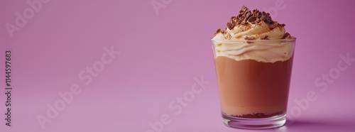 Creamy chocolate dessert in glass topped with whipped cream and chocolate shavings, set against vibrant purple background. photo