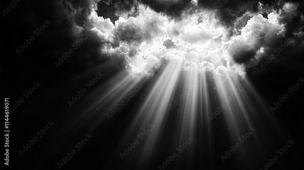 Fototapeta premium Dramatic sunbeams breaking through dark storm clouds in a black and white sky.