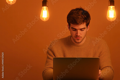 Focused young man working on laptop in cozy room with warm lighting for productivity enhancement photo