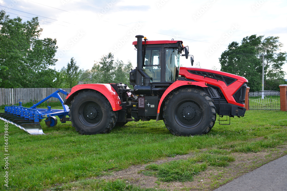 a red tractor with a black wheel with a plow on the side a red tractor with a black wheel with a plow on the side