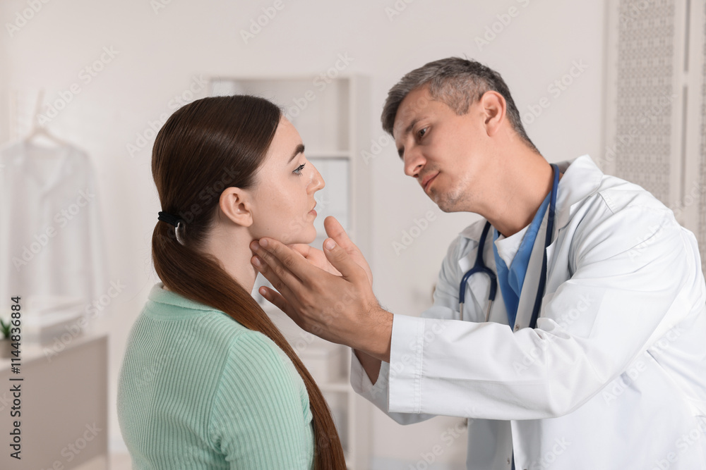 Fototapeta premium Doctor examining woman's throat in clinic during appointment
