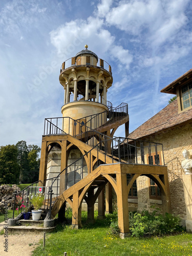 The Queen's Hamlet at the Trianon in Versailles, featuring charming rustic cottages, lush greenery, and a tranquil lake, embodying pastoral elegance and historic charm photo