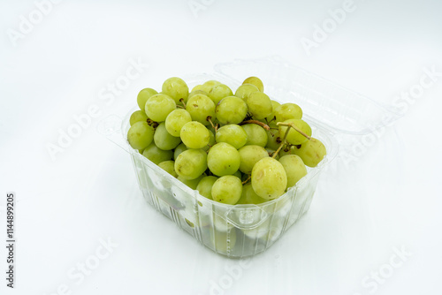 Fresh green grapes in clear plastic container, healthy snack option