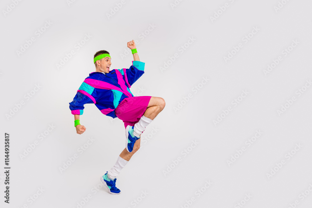 Energetic young man in vibrant retro sportswear executing a dynamic exercise on a white background, showcasing a fun and healthy lifestyle Energetic young man in vibrant retro sportswear executing a dynamic exercise on a white background, showcasing a fun and healthy lifestyle
