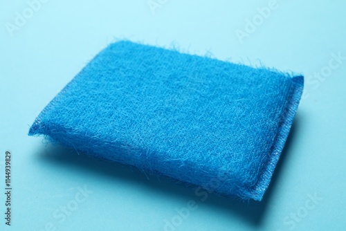 One sponge on light blue background, closeup