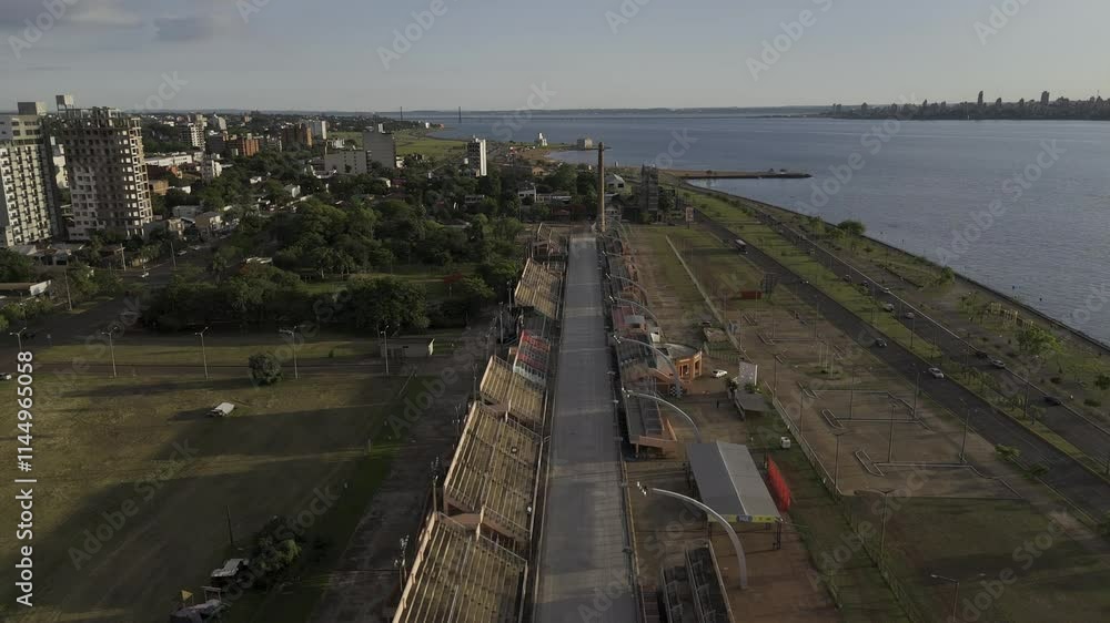 Drone flies low over sambodrome toward San Jose Beach at sunset in Encarnación, Paraguay Drone flies low over sambodrome toward San Jose Beach at sunset in Encarnación, Paraguay