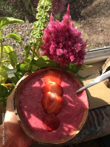 Hand Holding a Vibrant Green Smoothie: A Refreshing Blend of Health and Vitality on a Sunny Day, strawbeery, flowers and yogurt