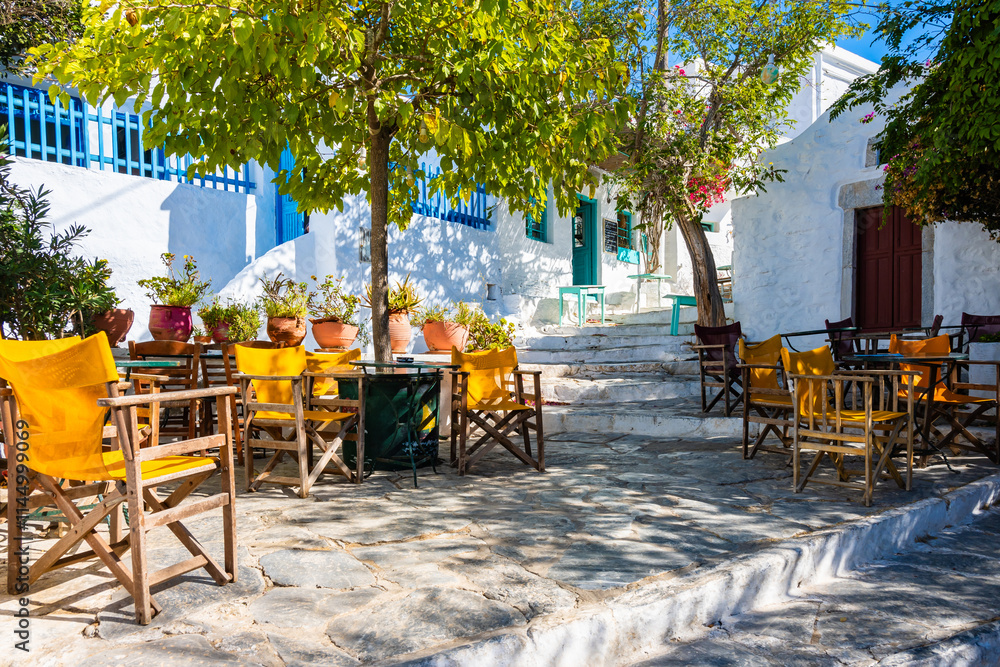 Tables with chairs in Greek cafe on square of Chora village, Amorgos island, Cyclades, Greece