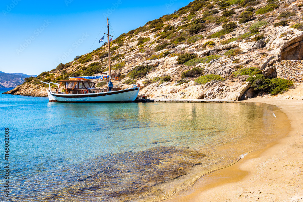 Traditional fishing boat anchoring in Maltezi bay with amazing beach, Amorgos island, Cyclades, Greece