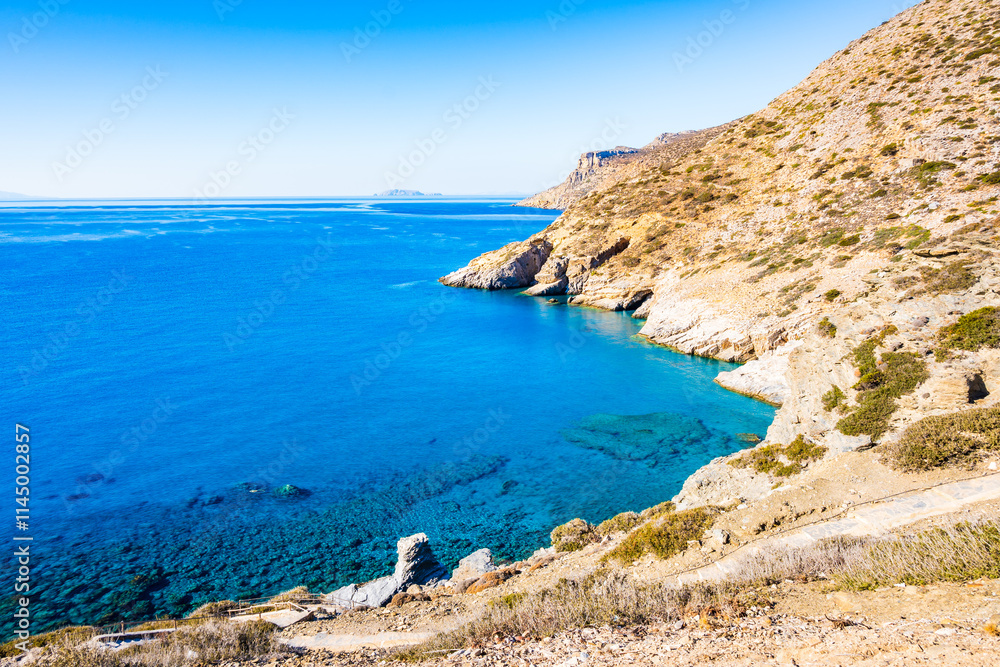 View of Mouros bay with azure blue sea and high cliffs, Amorgos island, Cyclades, Greece View of Mouros bay with azure blue sea and high cliffs, Amorgos island, Cyclades, Greece