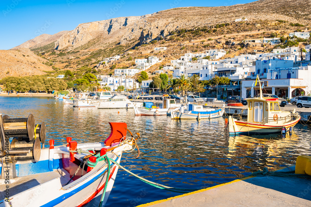 Fishing boat and sailing yachts anchoring in Aigiali port (Ormos Egialis) at sunset, Amorgos island, Cyclades, Greece